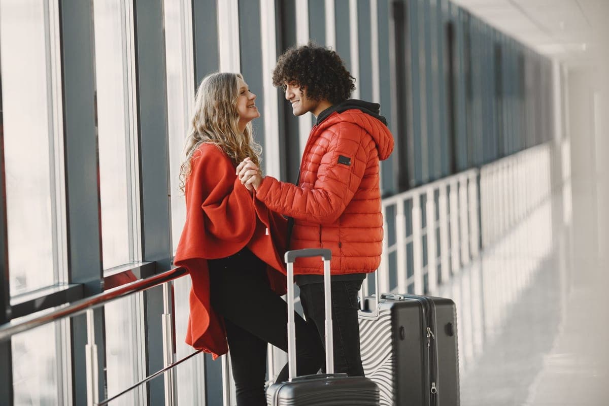 Travelers with luggage in an airport terminal setting off on a trip