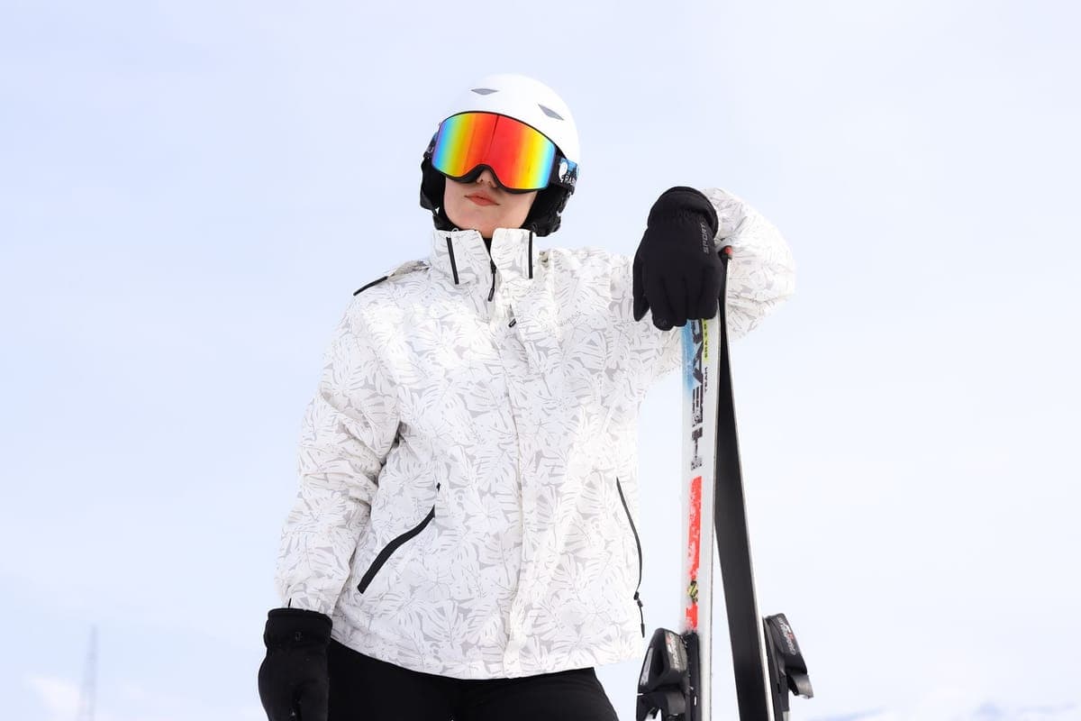 Adult skier standing with skis on a bright snowy mountain