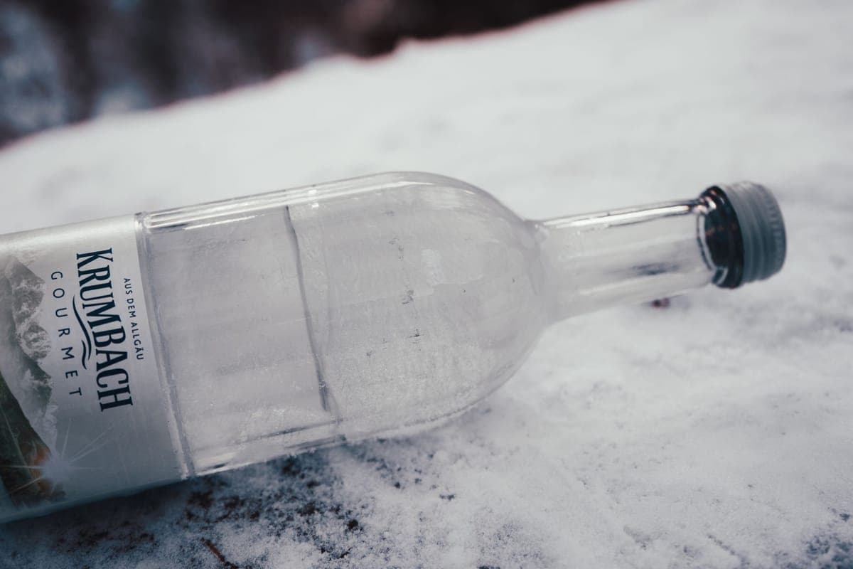 A frozen water bottle lying on fresh snow on a cold winter day
