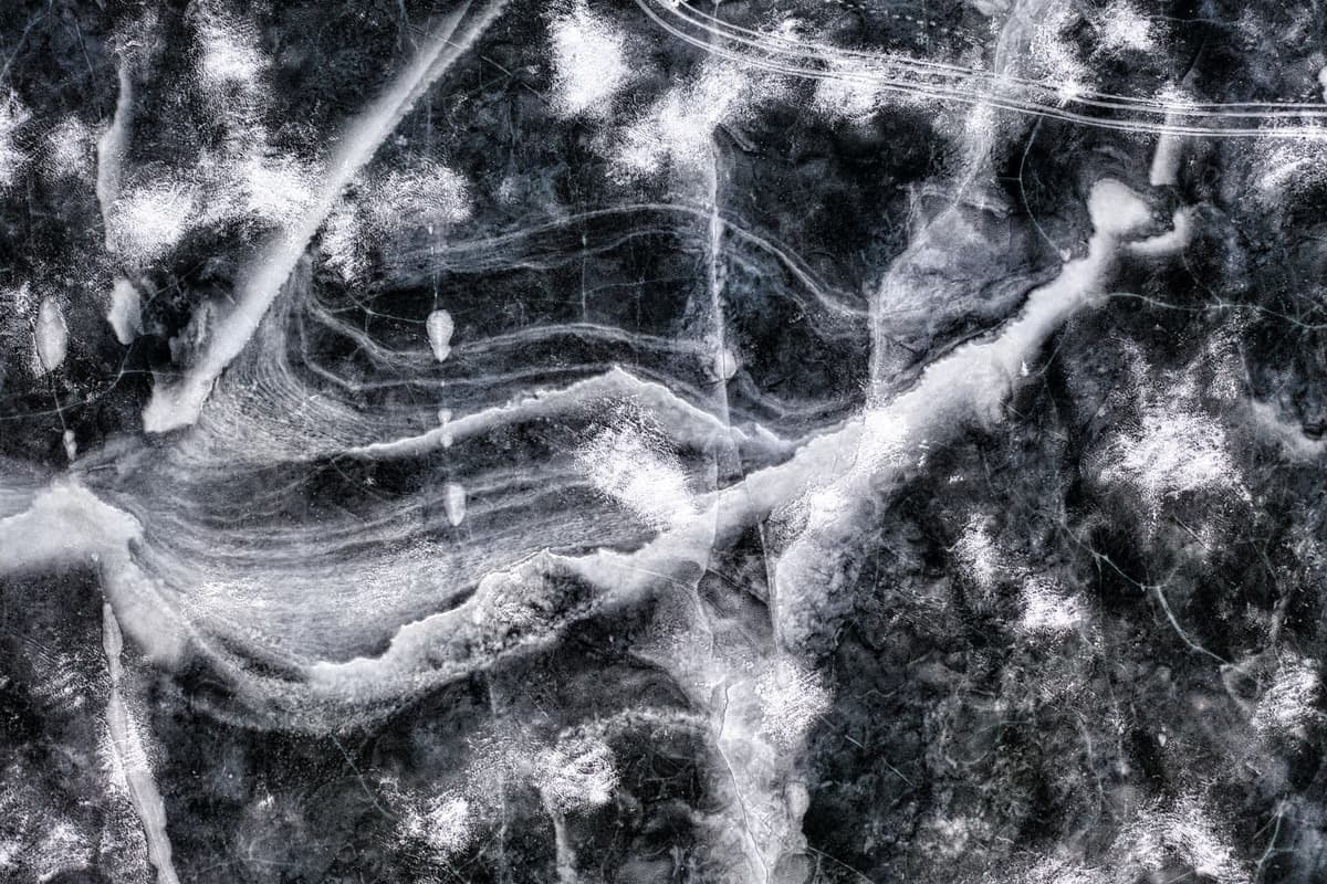 Aerial view of icy patterns and textures on a frozen lake in winter