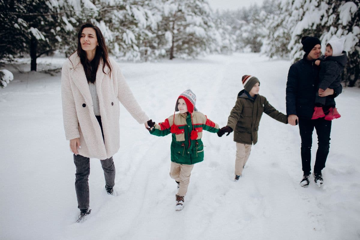 A family walking together through a snowy winter forest