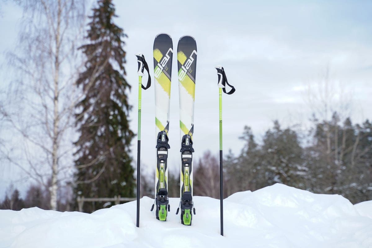 A pair of skis and poles standing upright in snow