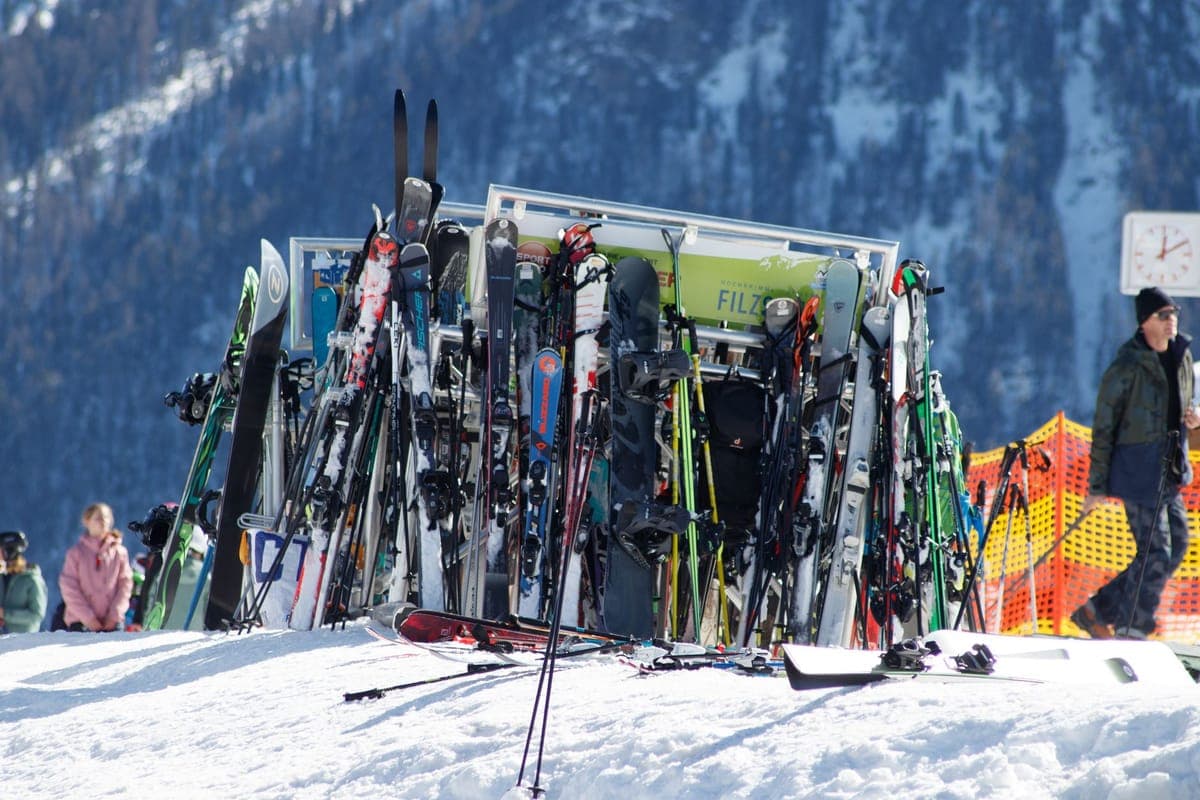 A rack of skis and snowboards outside a mountain resort building