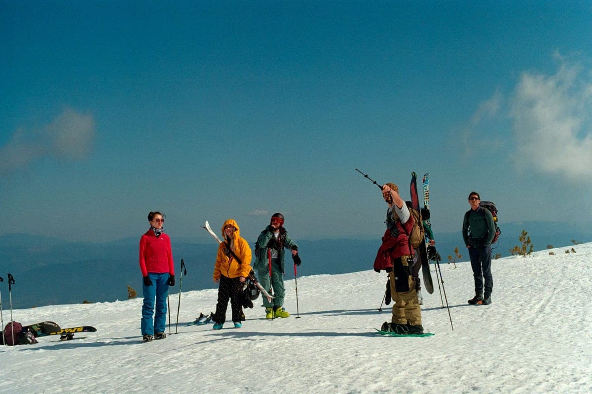 A group of skiers with their equipment on a snowy mountain