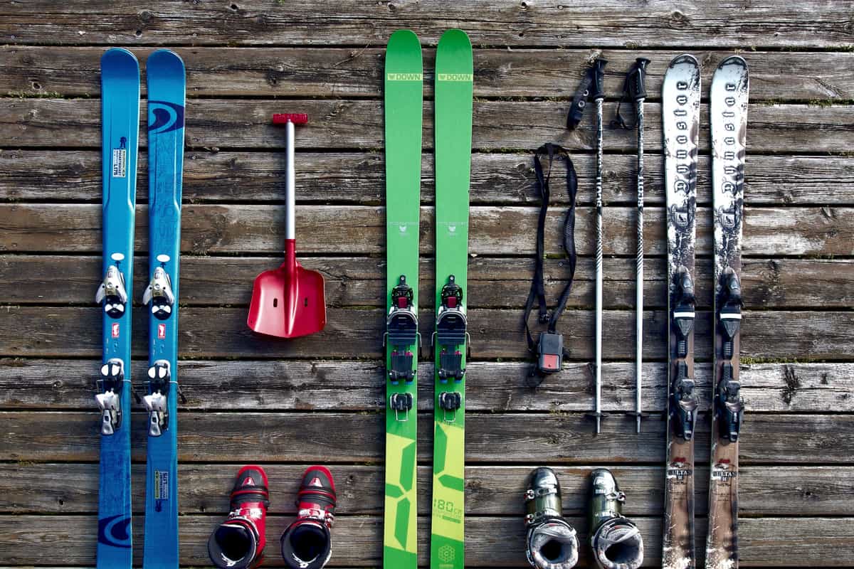 A collection of ski gear laid out on a wooden deck