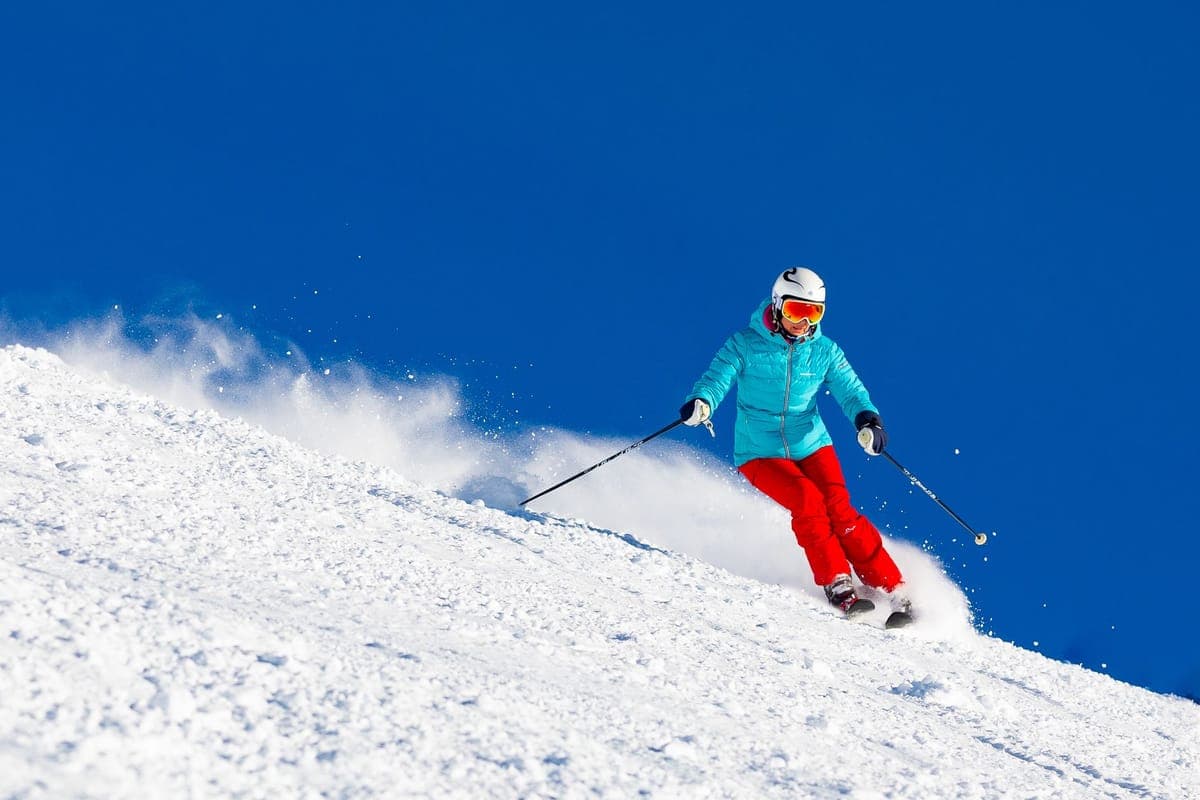 A woman skiing downhill on a bright winter day