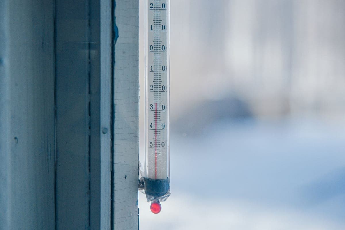 An outdoor thermometer against a frosty winter background