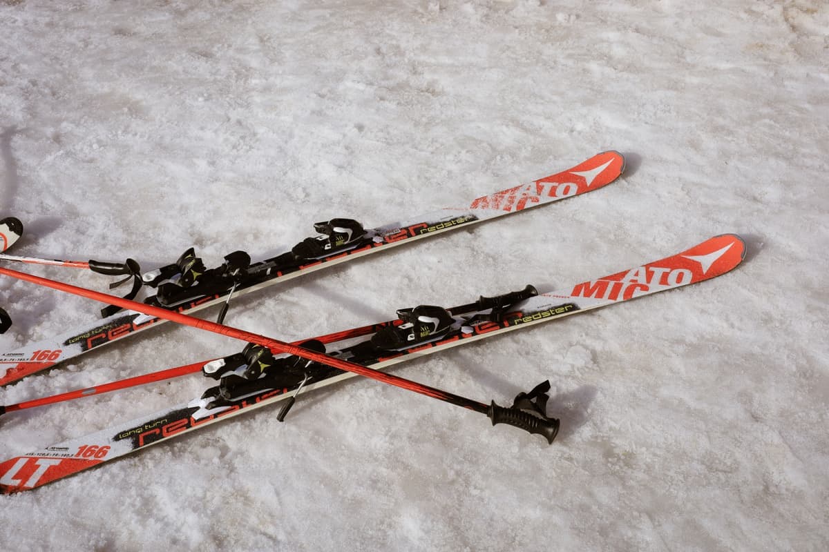 Red and black skis and poles resting on snow