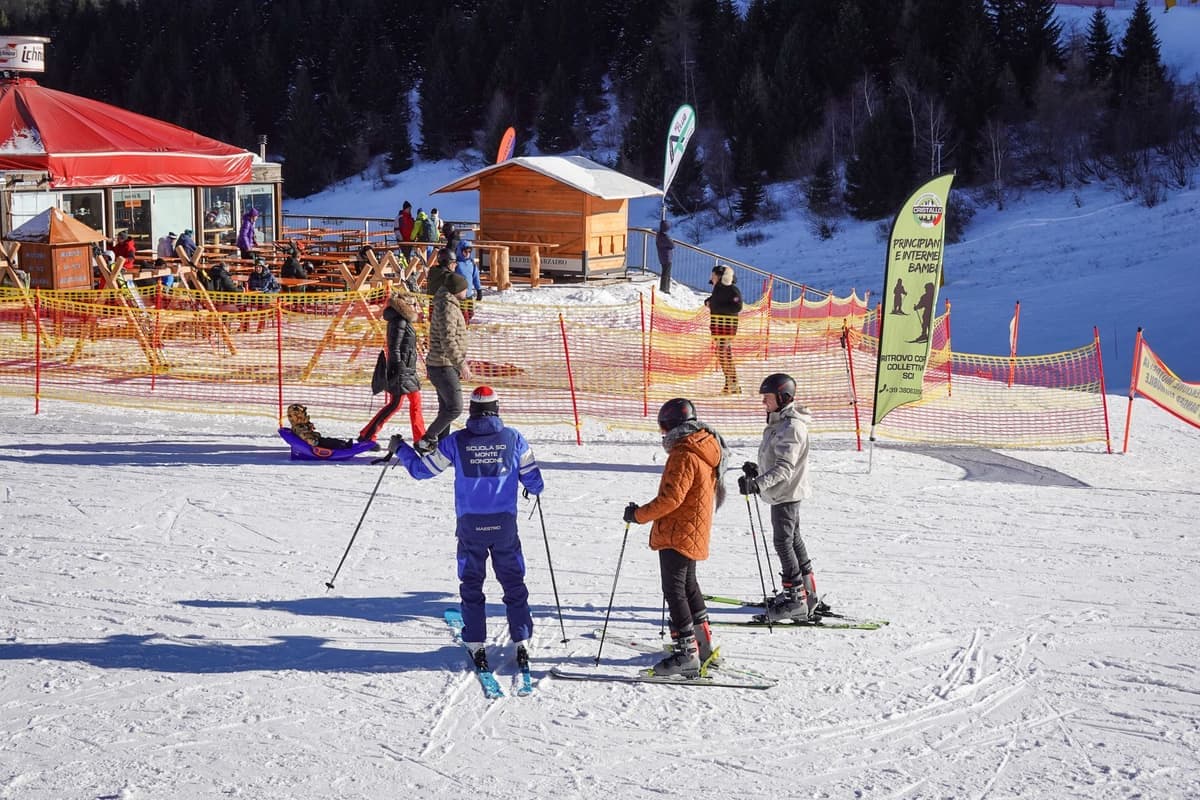 Skiers on a sunny slope at a ski resort during a winter day