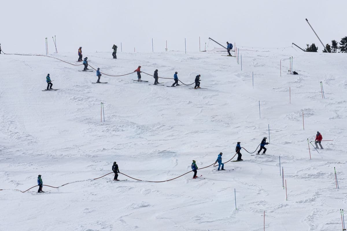 A group of skiers making their way up a snowy slope