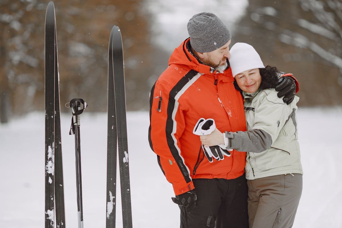 A couple in ski clothing standing together in a snowy winter scene