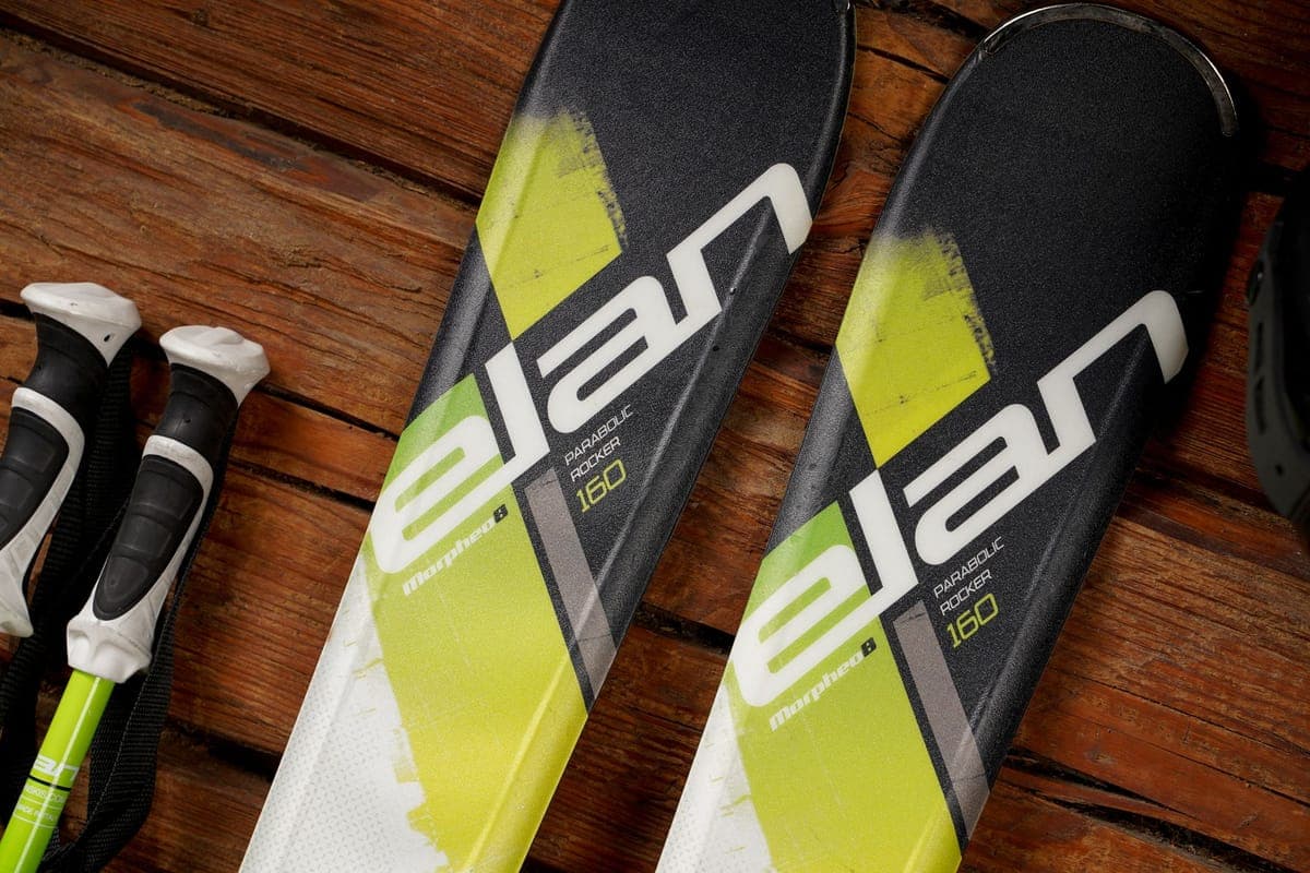 Detailed view of ski bases and edges resting against a wooden background