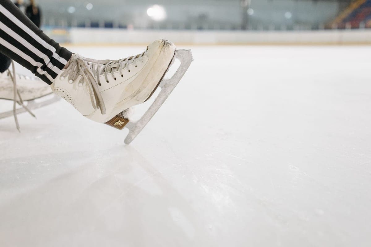 A detailed view of an ice skate resting on a smooth rink surface