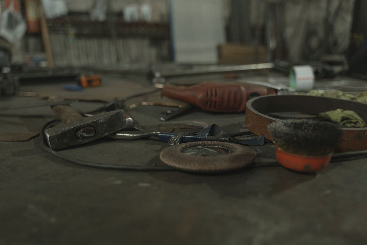 An assortment of hand tools spread across a workbench in a workshop