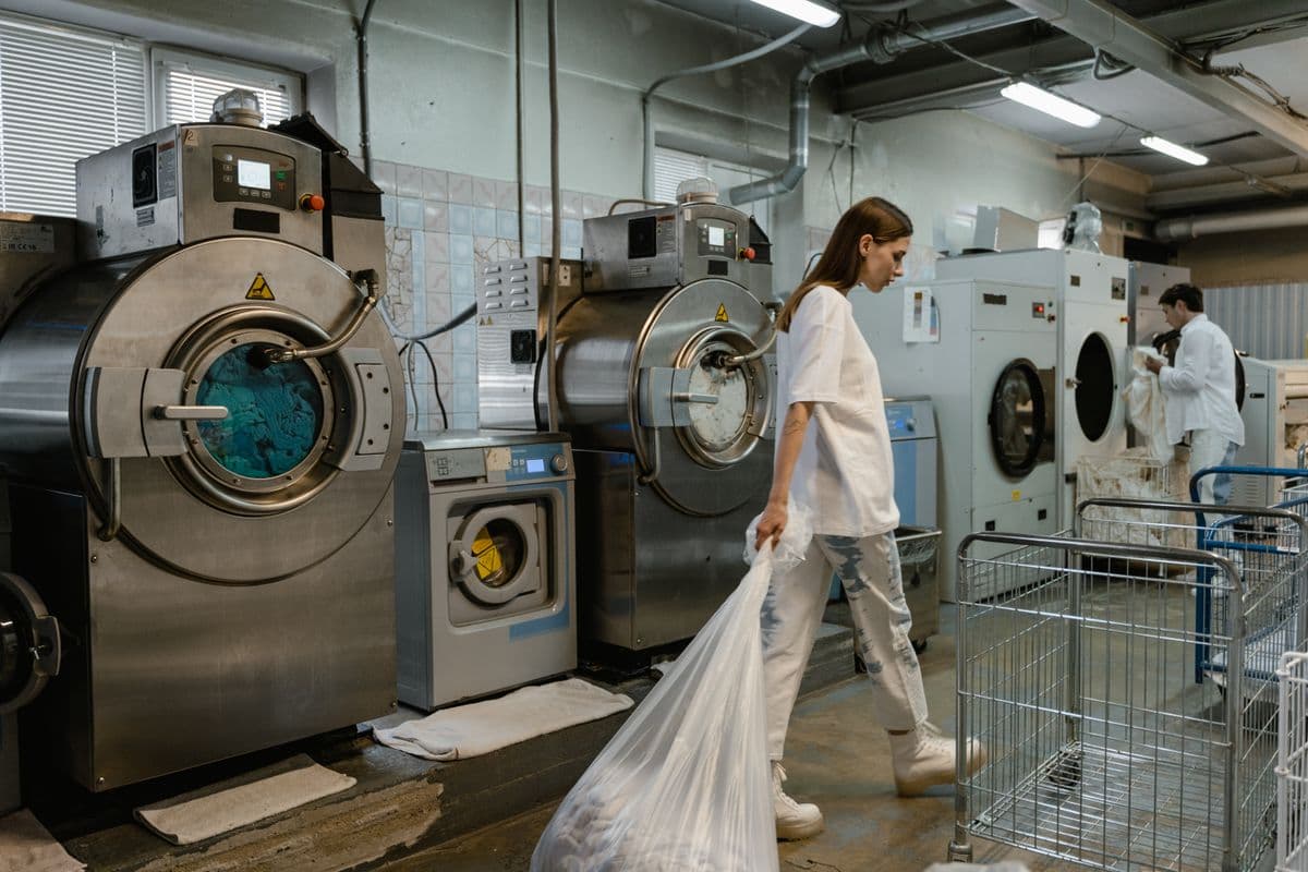 A row of large commercial washing machines in a laundry room