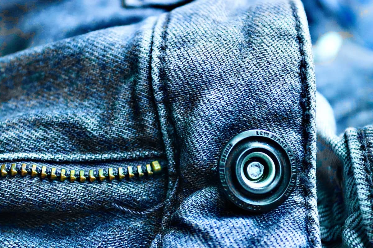 Close-up of fabric showing a button and zipper detail