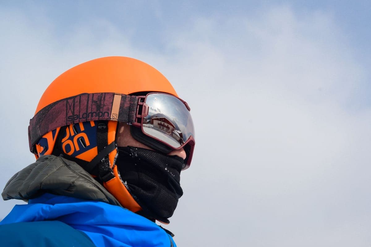 Close-up of a person in winter clothing wearing reflective ski goggles