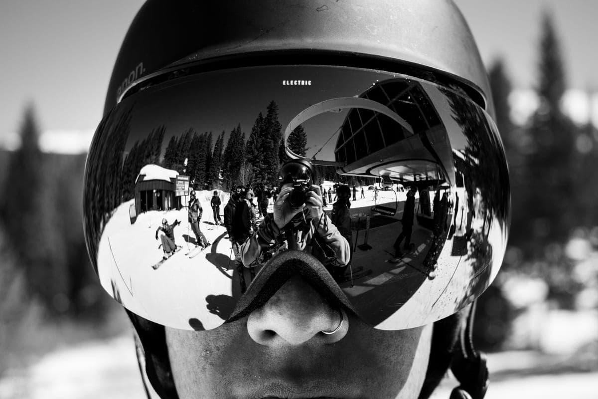 Close-up of ski goggles reflecting a snowy winter landscape