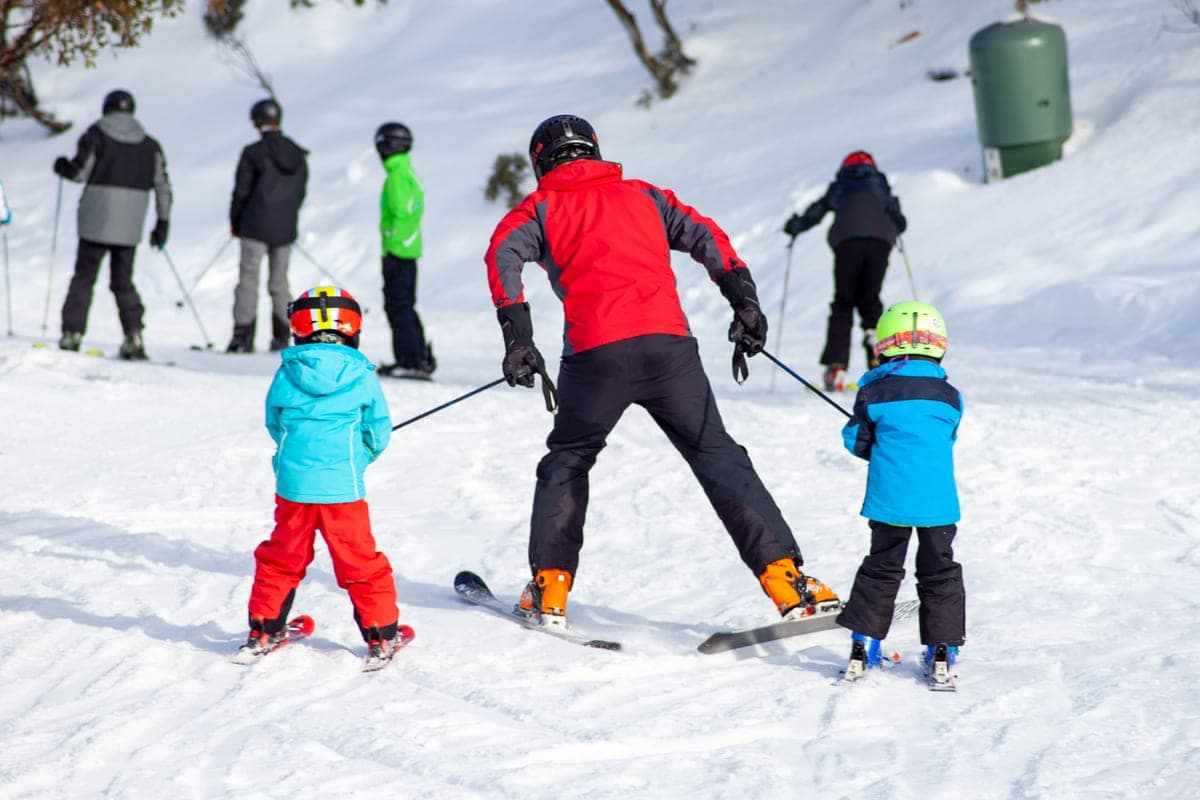 A group taking a skiing lesson on a snow-covered mountain