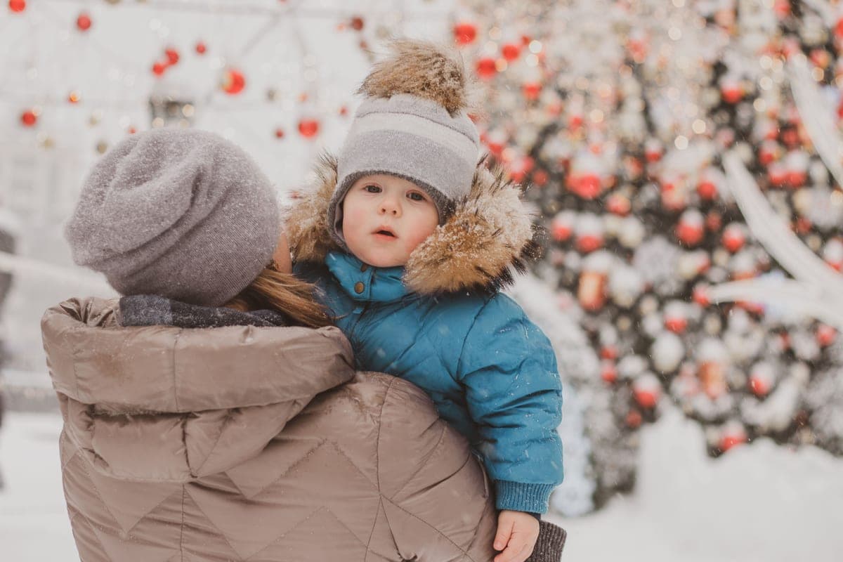 A parent and child sharing a winter moment in a snowy landscape