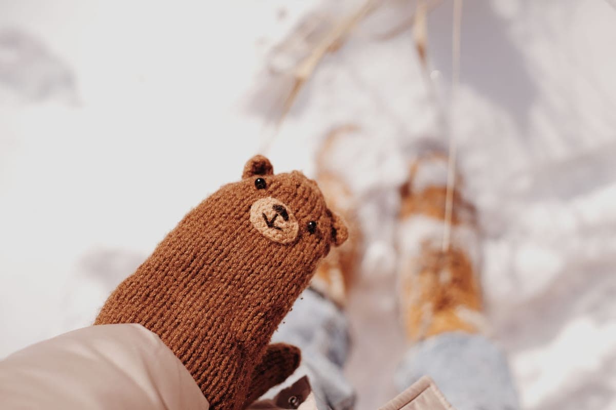 Close-up of a knitted mitten in a snowy winter setting
